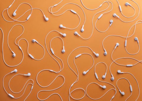 White earphones on orange background, 3D Rendering