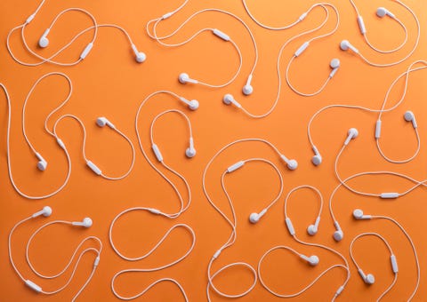 White earphones on orange background, 3D Rendering