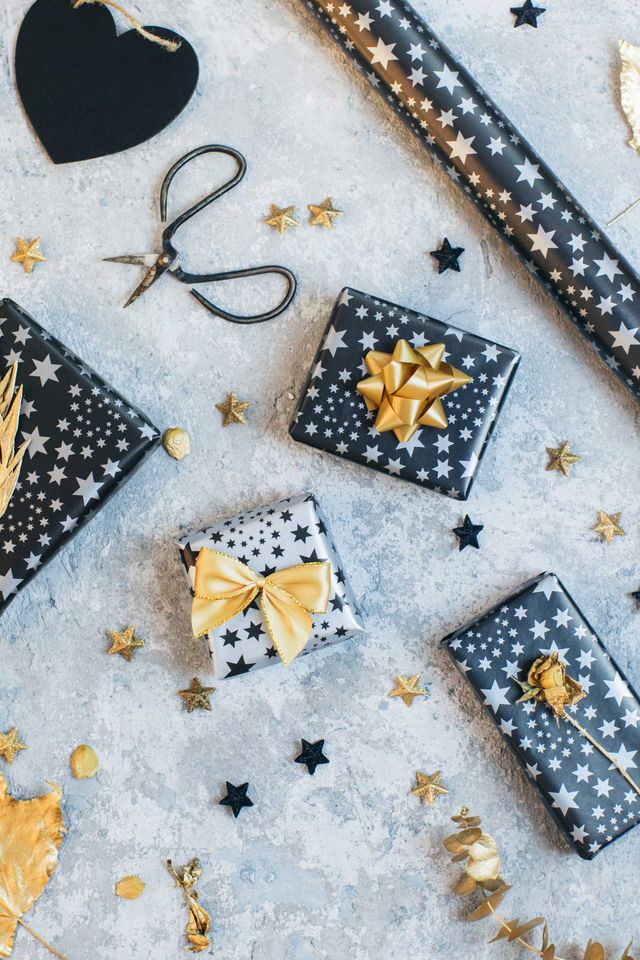 gift boxes wrapped in black and gold paper on vintage background