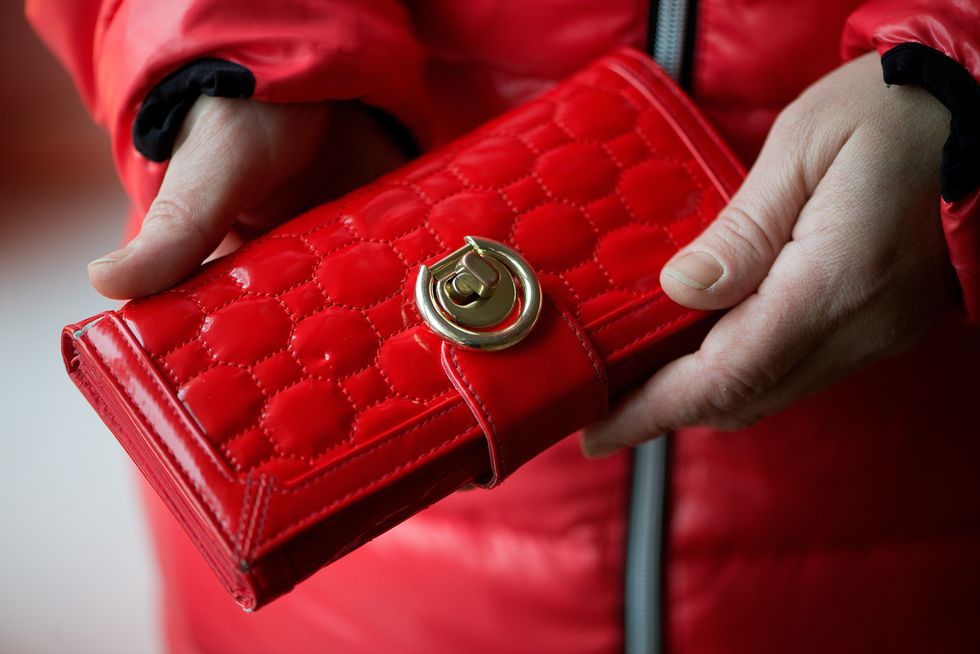 cropped image of woman holding red purse