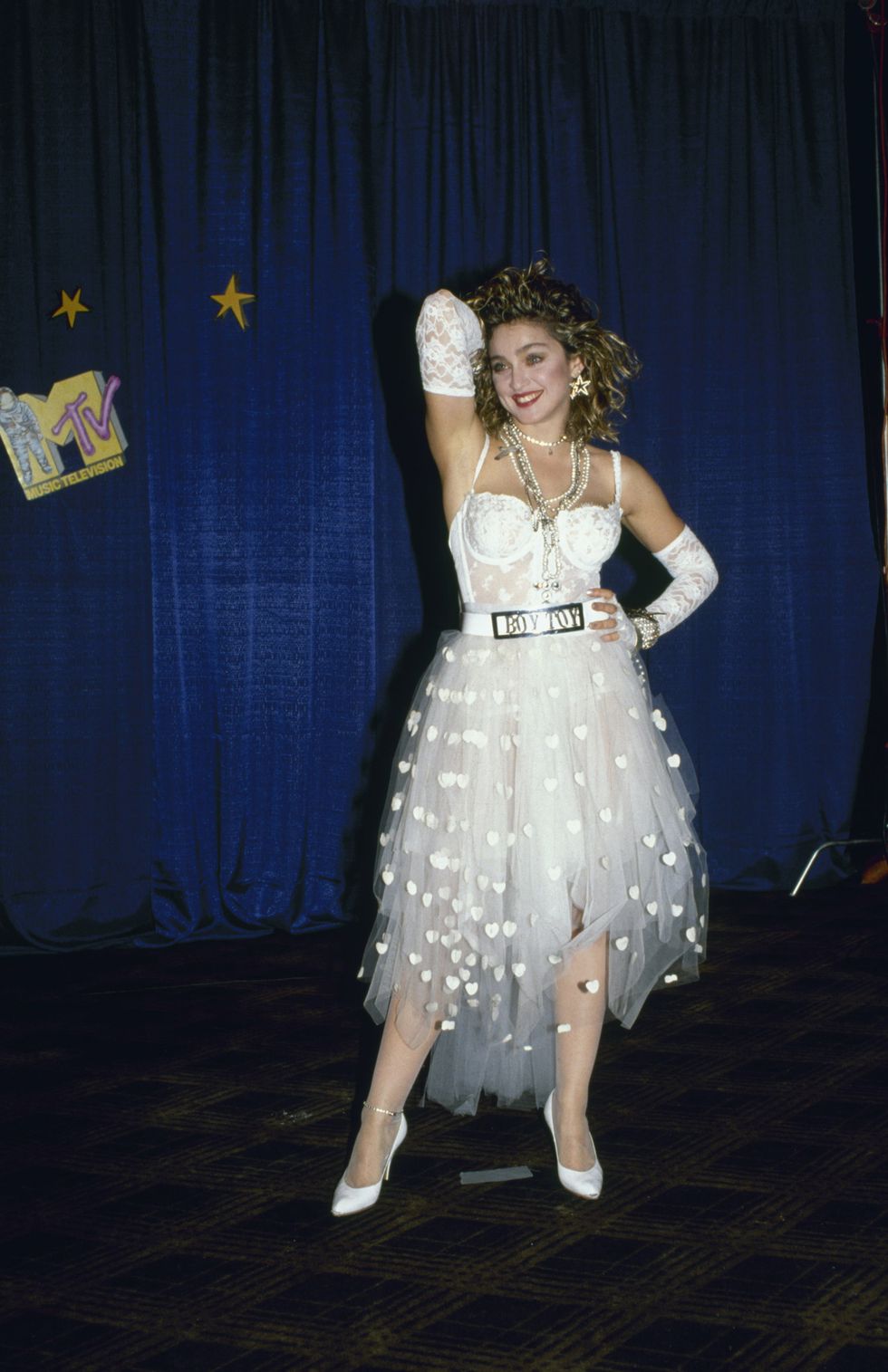 american singer and actress madonna, dressed in white lace lingerie, pearls, and a 'boy toy' belt buckle, stands with one hand on her head and one on her hip at first annual mtv video music awards, held at tavern on the green, new york, new york, september 14, 1984 photo by david mcgoughdmithe life picture collection via getty images