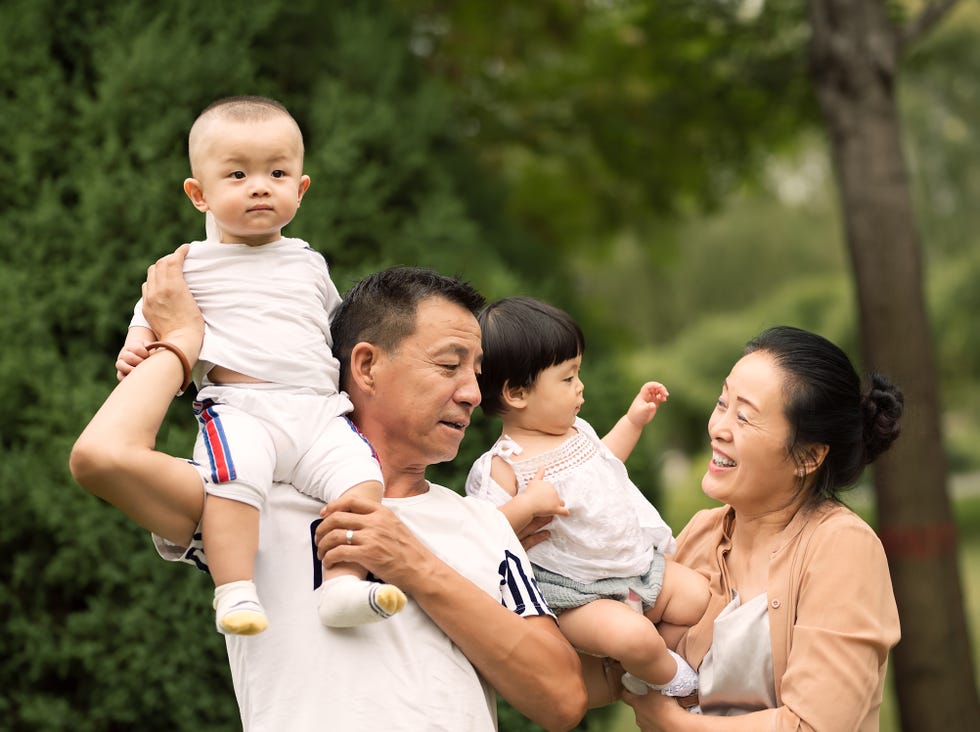 grandparents and grandchildren standing in park