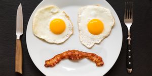 sad and negative face made from fried eggs and bacon on plate this is the typical breakfast in a low carb high fat keto ketogenic or paleo diet which can help with weight loss and overall well being