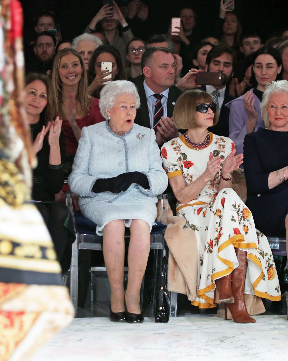 london, england   february 20  queen elizabeth ii sits with anna wintour, caroline rush l, chief executive of the british fashion council bfc and royal dressmaker angela kelly r as they view richard quinns runway show before presenting him with the inaugural queen elizabeth ii award for british design as she visits london fashion weeks bfc show space on february 20, 2018 in london, united kingdom photo by yui mok   poolgetty images