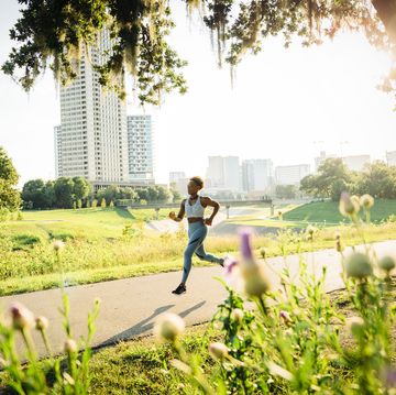 woman running Top on path in park beyond wildflowers