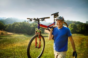 hombre llevando una bicicleta de montaña