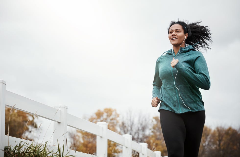 shot of an attractive young woman going for a run in nature