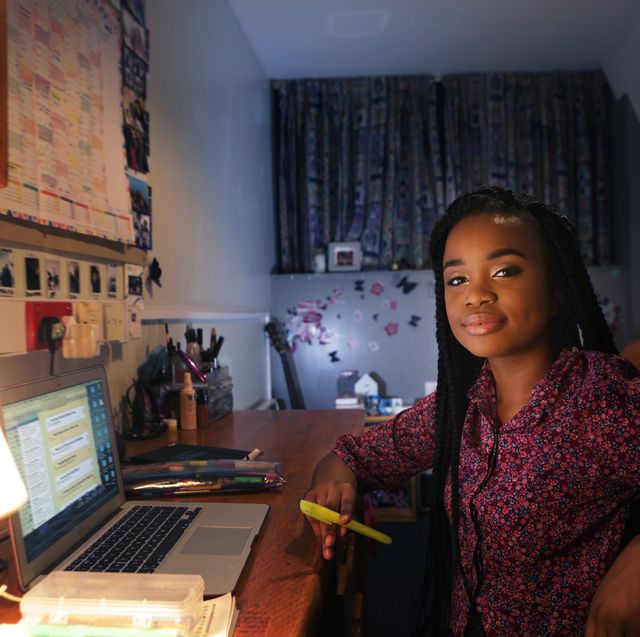 student working at desk in bedroom at night