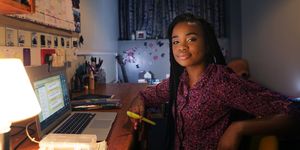 student working at desk in bedroom at night