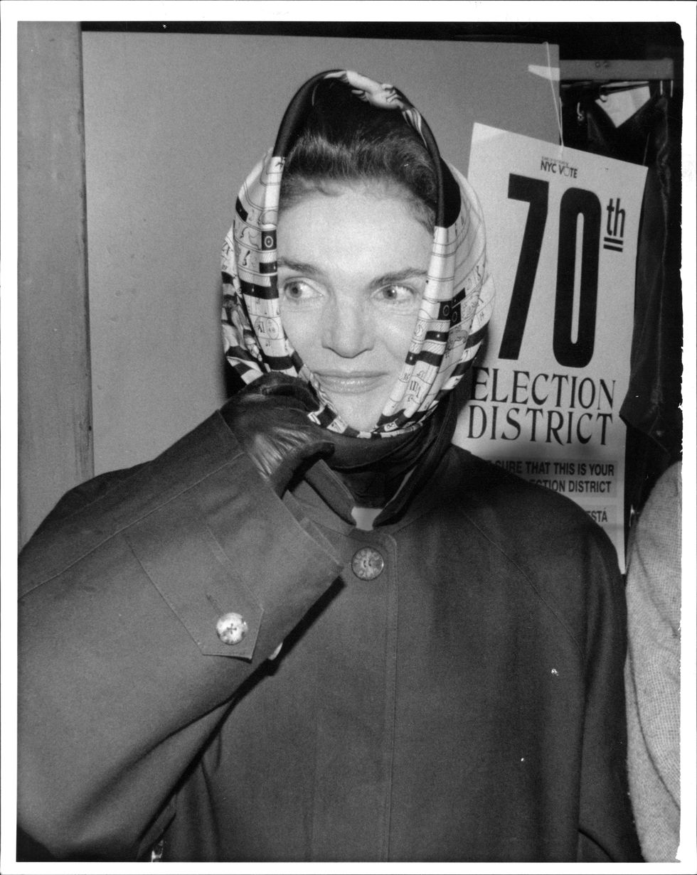 jackie onassis, leaving the east 88 st polling place the robert f kennedy school passes the abrams family, waiting on line to vote, and shakes hands with candidate robert abrams as he and his family wife diane, daughter rachel age 16, daughter becky age 6 to vote other pictures are of jackie onassis waiting on line, scarf covering her head and part of her face, jackie signing the registration book jackie waiting to enter the voting booth with a election district sign in back of her november 03, 1992 photo by robert kalfusnew york postphoto archives, llc via getty images