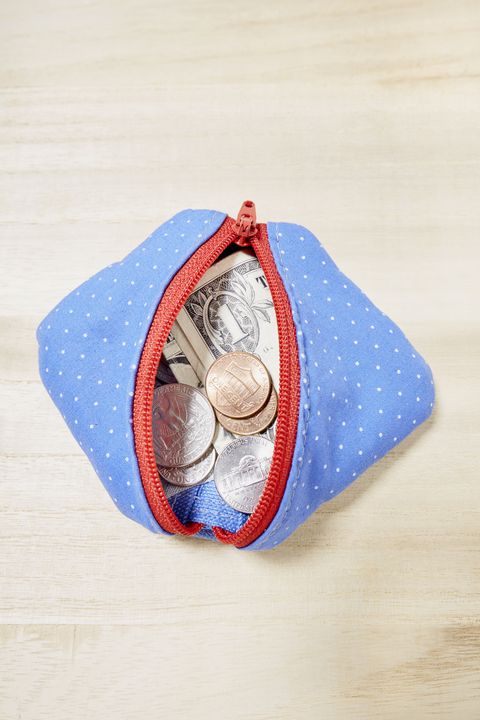 High angle view of a purse full of coins and one American One Dollar Bill