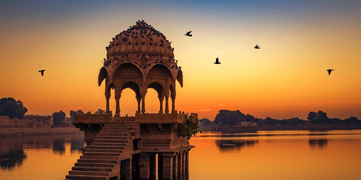 Gadisar lake at Jaisalmer Rajasthan at sunrise with ancient temples and archaeological ruins. gadisar lake gadi sagar at jaisalmer rajasthan is a popular tourist destination with ancient temples and archaeological ruins photograph shot at gadisar lake at sunrise