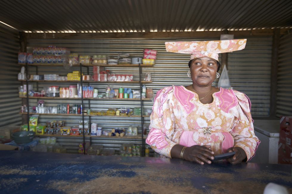 Herero woman behind counter of a shop, Sesfontein, Kaokoland, Namibia