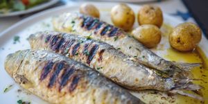close up of grilled sardine fishes served in oil with baked potatoes, a traditional portuguese food, portugal