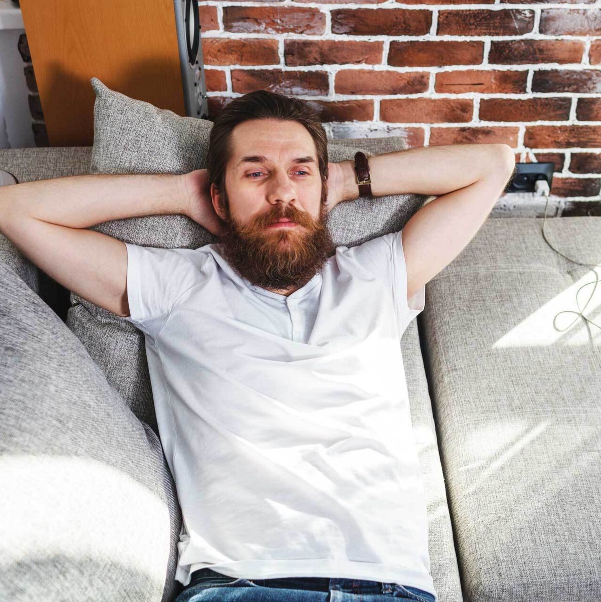 man reclining on sofa with serious expression