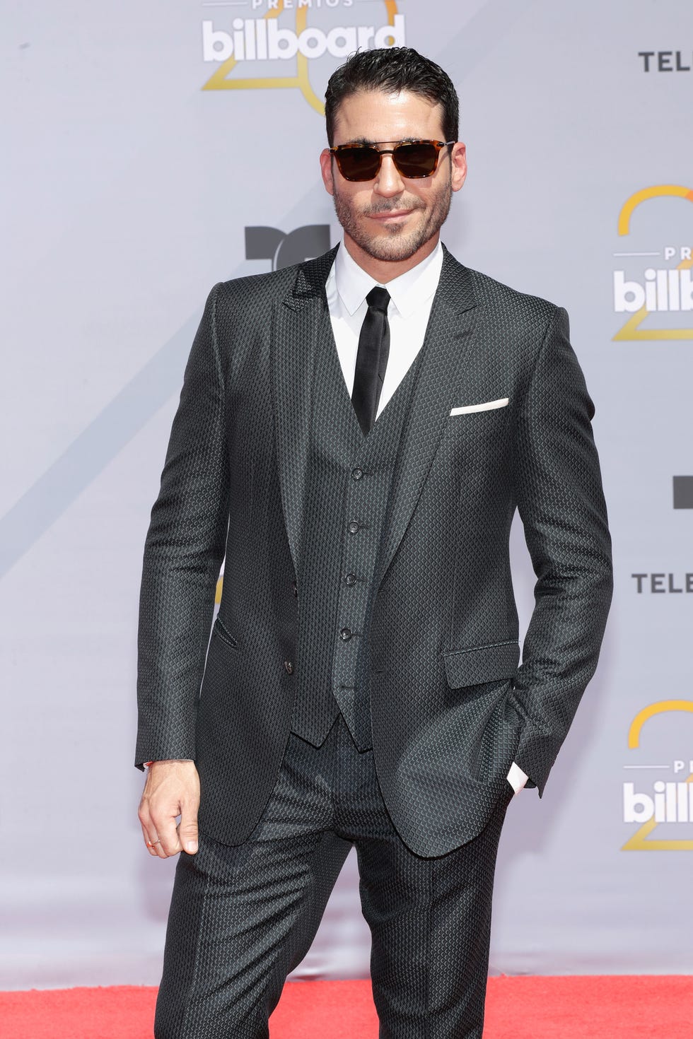 Suit, Eyewear, Clothing, Formal wear, Hairstyle, Tuxedo, Red carpet, Carpet, Fashion, Facial hair, 