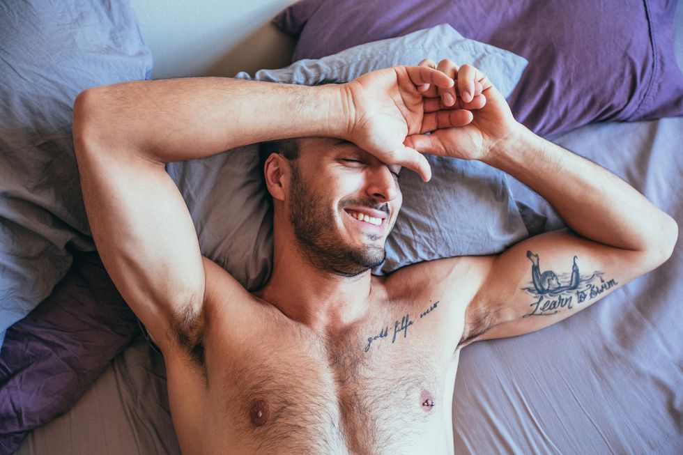 sexy man lying in bed, sexy man smiling in bed, sexy man laughing in bed