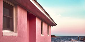 pink beach house with lawn near the atlantic sea with beautiful color gradient sky