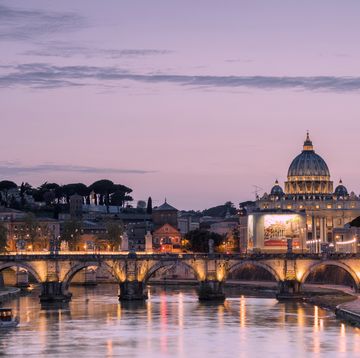 dusk on tiber river with bridge umberto i and basilica di san pietro in the background, rome, lazio, italy