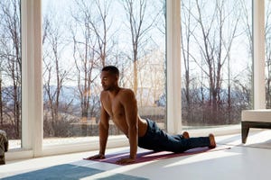 Man practicing upward facing dog position at home