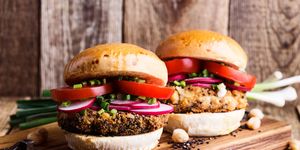 vegan meal chickpea veggie burger with fresh vegetables on rustic cutting board