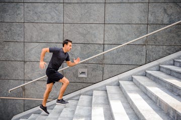 sporty man running up steps in urban setting