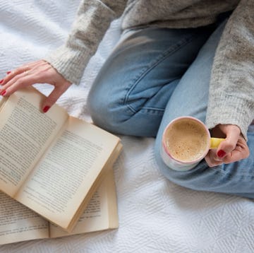 una chica leyendo con un cafe en la mano