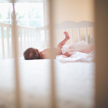 baby girl lying down in crib at home