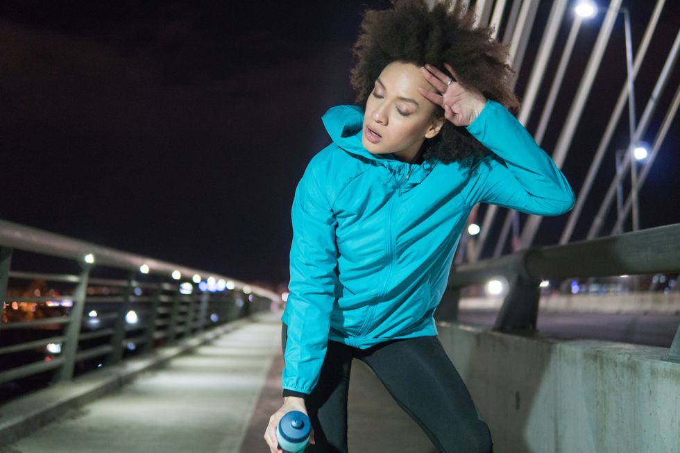 female jogger taking a break after exercising at night