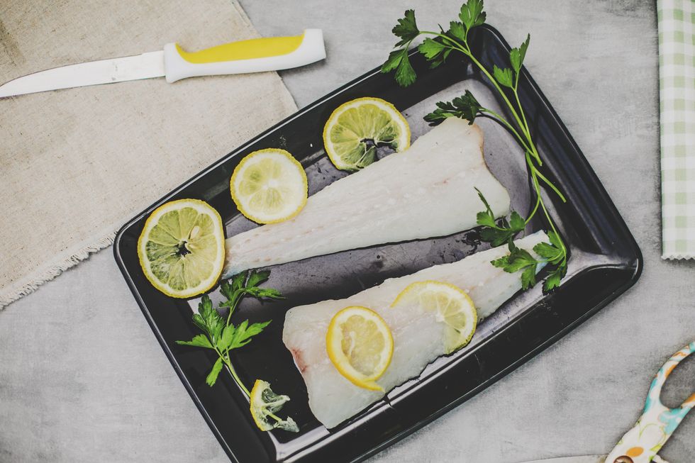 fresh sliced raw hake fish on the cuting board