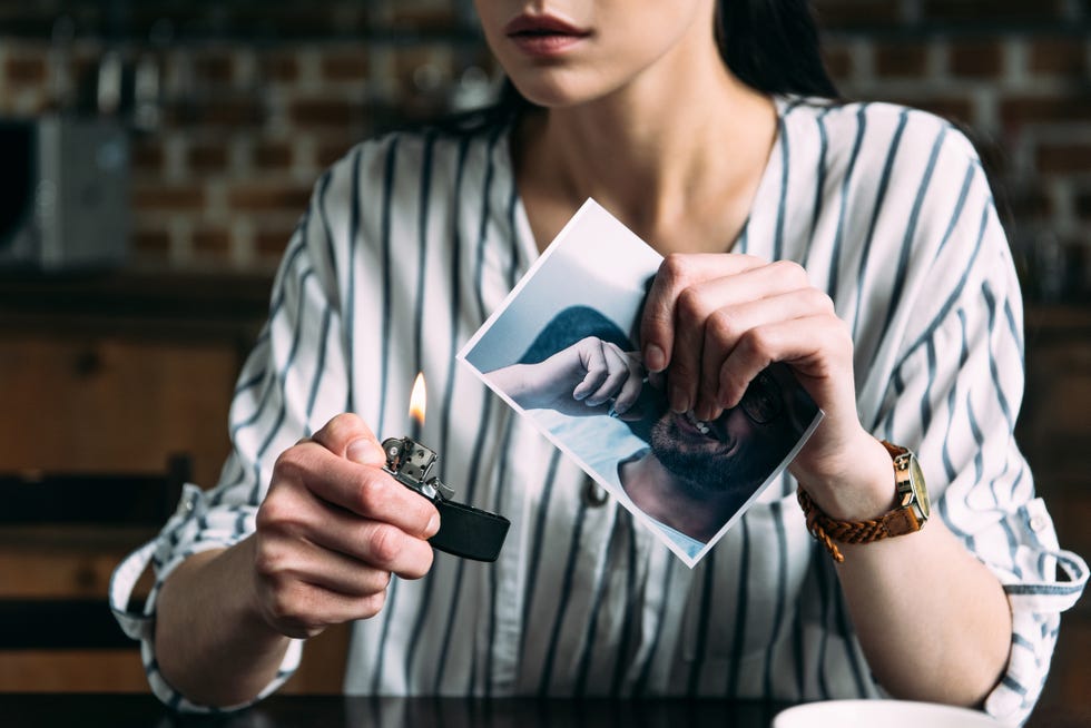 cropped shot of young woman burning photo card of ex boyfriend