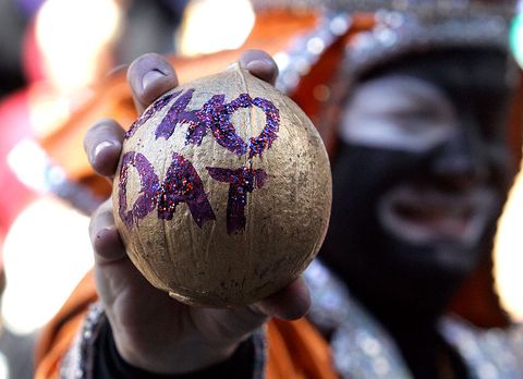 n member of the zulu social aid and pleasure club displays a gold coconut with the words who dat during mardi gras day
