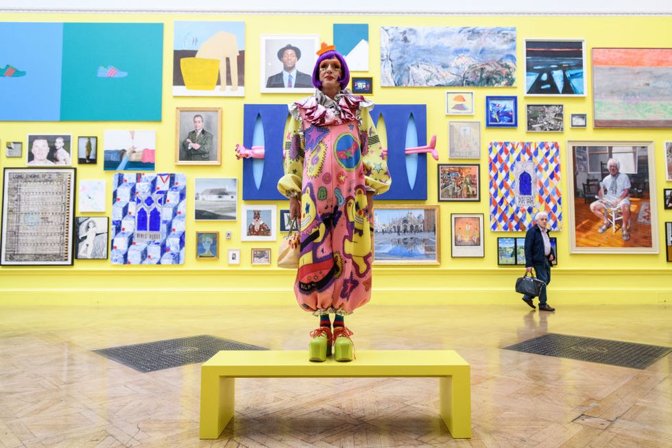 london, england   june 05  artist grayson perry c poses for photographers during a press preview of the 250th summer exhibition at royal academy of arts on june 5, 2018 in london, england  the summer exhibition runs from 12 june to 19 august 2018 and allows established and emerging artists to display their work, side by side, with all forms of contemporary art, including such mediums as sculpture, painting, video installation and textile  photo by leon nealgetty images