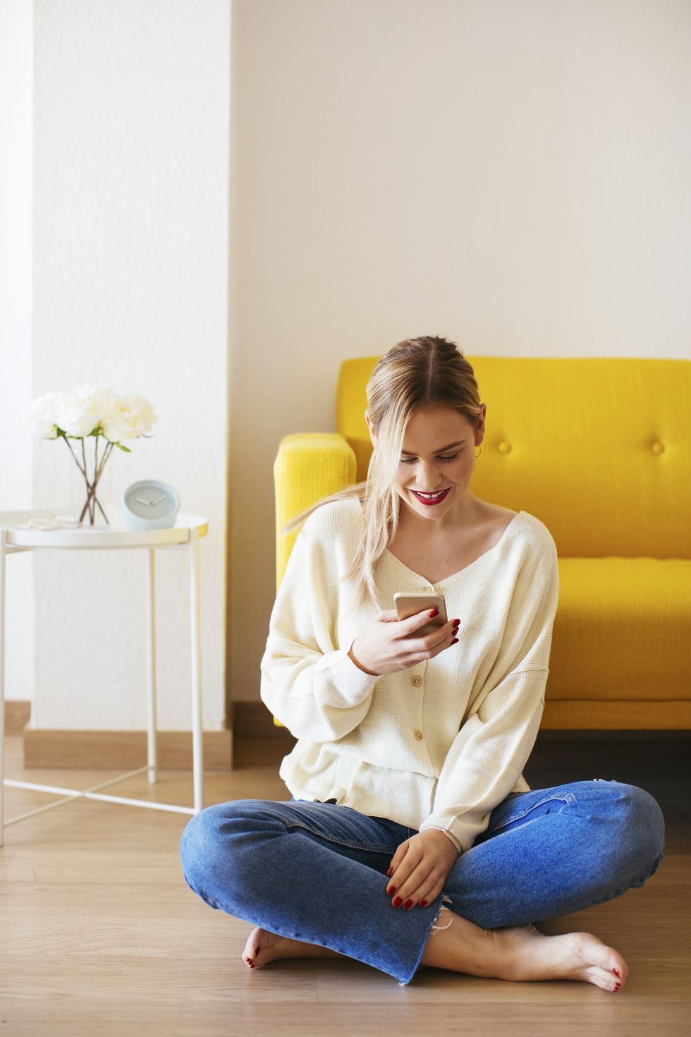 Blonde woman using smartphone at home