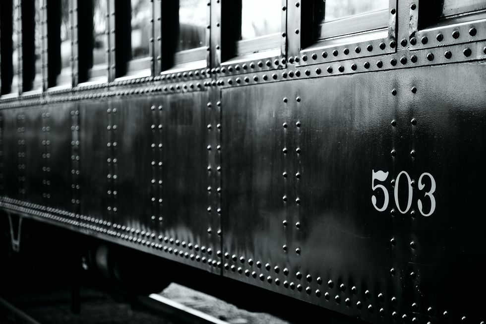 historical train car 503 at the essex train museum in essex connecticut black and white reflections of train museum visible in the shiny black surface of the car focus fades off in the distance of the train car