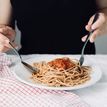 young attractive beautiful girl woman eating italian food a plate of pasta with sugo, lifestyle italian food concept, , homemade food, cooking at home,