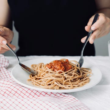 young attractive beautiful girl woman eating italian food a plate of pasta with sugo, lifestyle italian food concept, , homemade food, cooking at home,