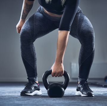 a woman exercising with kettlebell at the gym