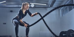 vrouw traint met touwen tijdens cross training
