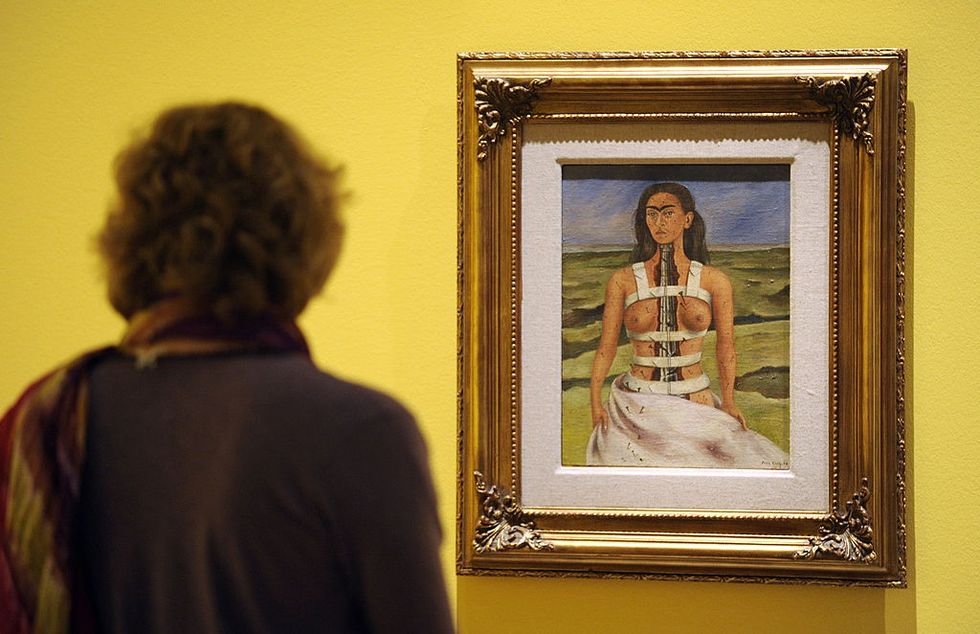a visitor looks at the painting the broken column by mexican artist frida kahlo during a press preview on april 29, 2010 at the martin gropius bau museum in berlin from april 30 to august 9, 2010, the museum presents a retrospective on the important painter known for her self portraits often depicting her own pain afp photo john macdougall photo credit should read john macdougallafp via getty images