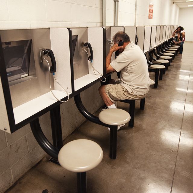 detention officer rene ansleyr looks on as visitors use a video phone to communicate during visiting hours with a friend or relative incarsarated inside sheriff joe arpaios maricopa county tent city jail may 3, 2010, in phoenix, arizona this area of the tent city houses misdemeanor offenders   afp photopaul j richards photo credit should read paul j richardsafp via getty images