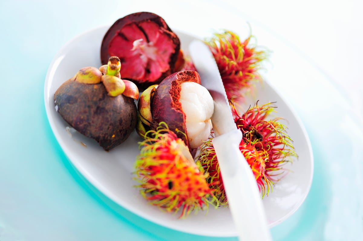 partly peeled mangosteen and rambutans, closeup