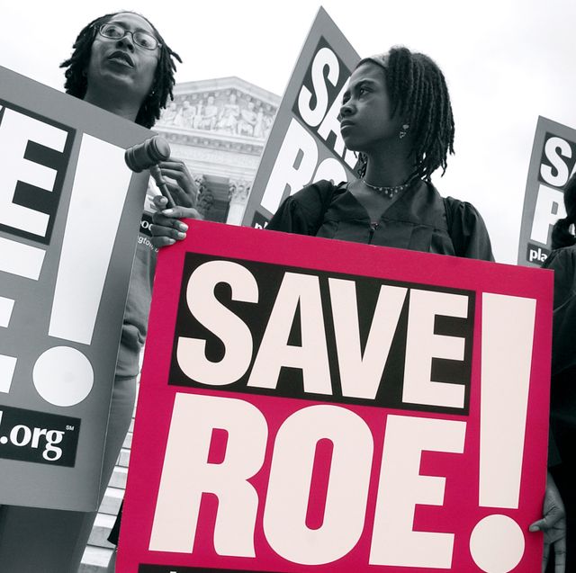 a woman holding a sign that says save roe