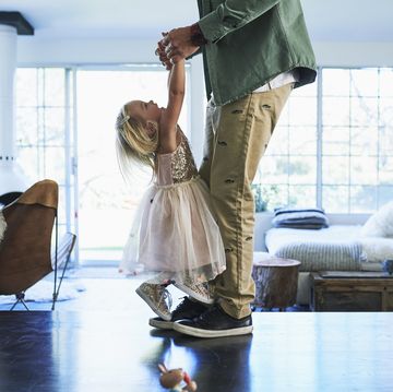 daughter standing on feet of father dancing