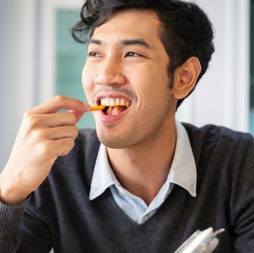young college students adult male sat eating snack with happiness in room