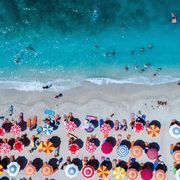 Aerial View Of Colorful Umbrellas On Shore At Beach