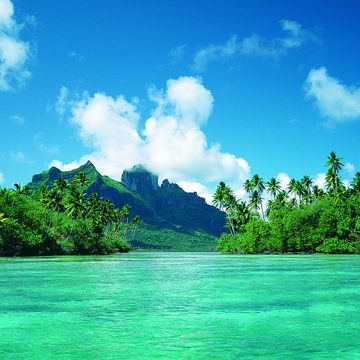 beautiful polynesian island seen from the sea with mountain in the distance