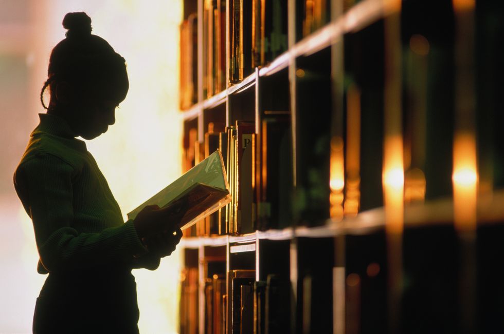 girl 68 looking at book in library, silhouette