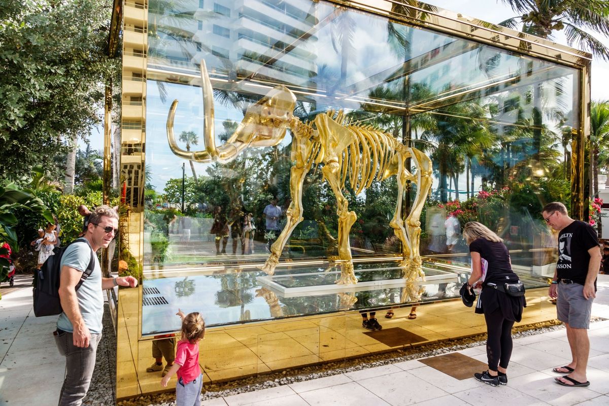 Dit beeldhouwwerk van Damien Hirst het vergulde skelet van een mammoet is te zien in Miami Beach Florida en draagt de titel Gone but not Forgotten Verdwenen maar niet vergeten Als het aan de nieuwe startup Colossal ligt zullen tientallen genen van de uitgestorven wolharige mammoet worden ingebracht in het DNA van Aziatische olifanten waardoor er een nieuwe kruising zal ontstaan die uitstekend is aangepast aan de kou van het Noordpoolgebied