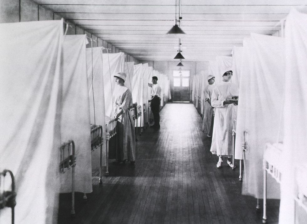 Verpleegsters en een verpleeghulp verzorgen patinten op de influenzazaal van het Walter Reed General Hospital in Washington DC In de zomer van 1919 waren wereldwijd inmiddels tientallen miljoenen mensen aan de nieuwe griep overleden en tastten wetenschappers nog in het duister over de oorzaak van de pandemie